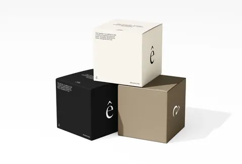Sand, black and white jewellery boxes stacked on a white ground.