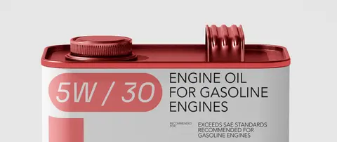 A red and white Emoil engine oil tin with a 5W/30 grade pill, on a pale ground.
