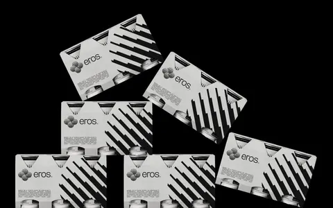 Eros cardboard multipack cartons stacked at angles on black.