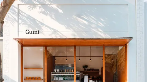 The Gumi cafe front with the wordmark above a timber-framed window.