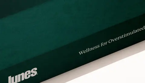 A deep green Lunes box with the line Wellness for overstimulated lives.