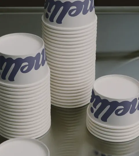 Stacks of white Mellie ice cream cups with navy script lettering.