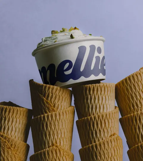 A Mellie cup of ice cream on a stack of waffle cones.
