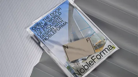 A clear plastic mailer holding NobleForma papers, on ribbed metal.