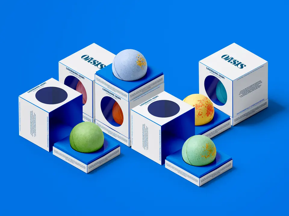 Four cube boxes with cut-out windows showing coloured bath bombs, on a bright blue ground.
