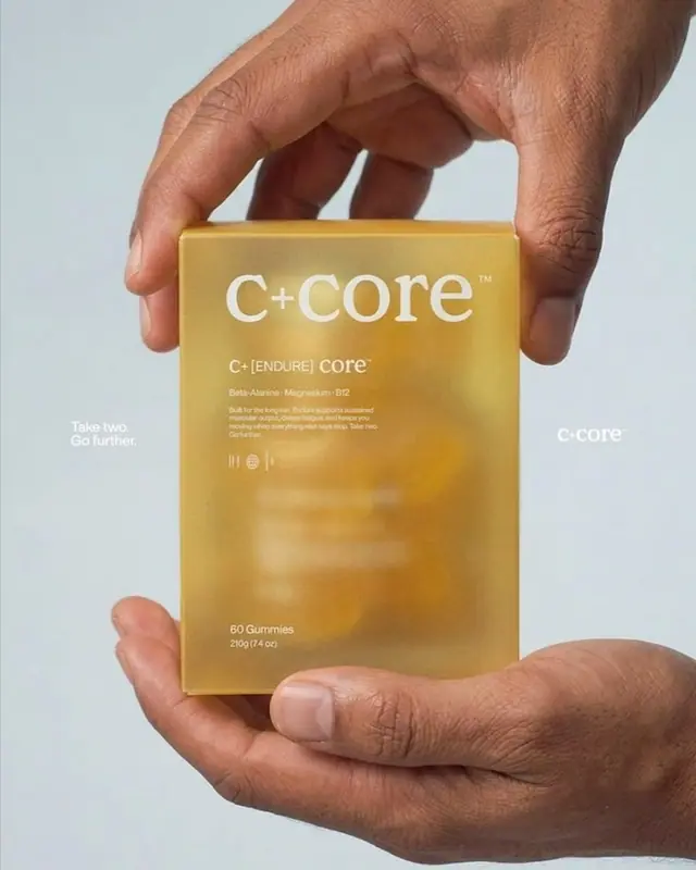 Hands holding a frosted amber supplement box against a pale blue ground.