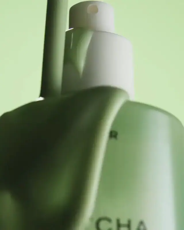 Close-up of a green pump bottle turning slowly.